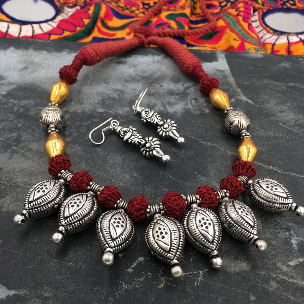 Oxidised leaf amulet necklace in red thread and golden dholki beads